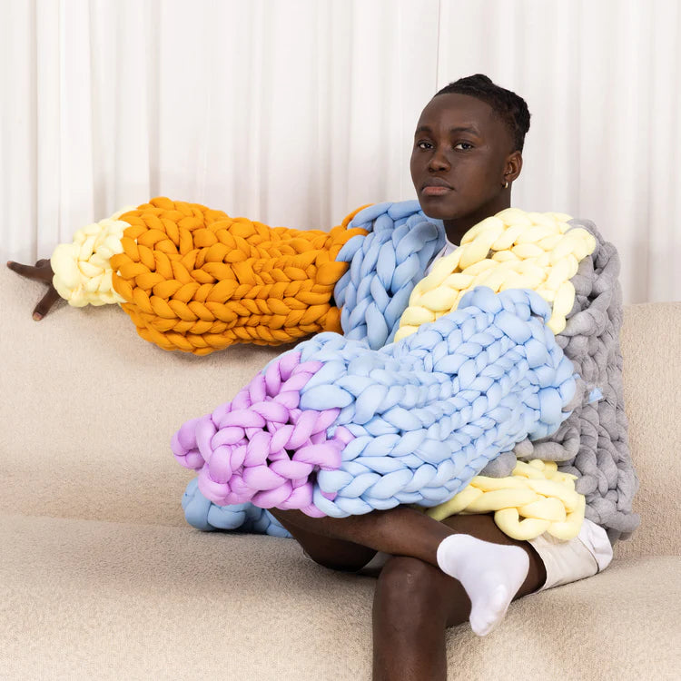 A model wearing a cardigan made from different coloured chunky yarn balls