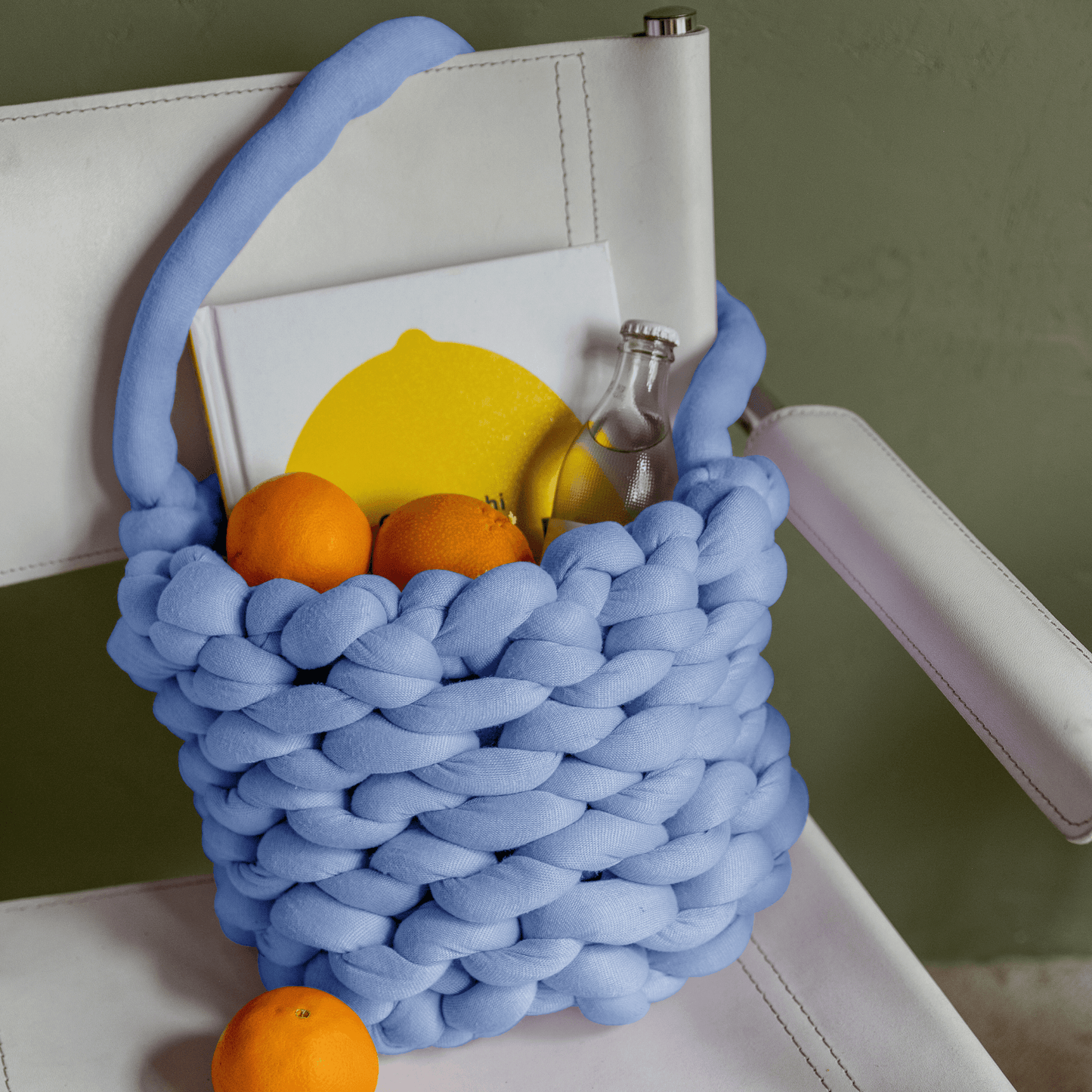 Chunky thread blue tote bag with items inside hanging off a chair